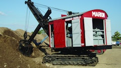 The power cord for the National Construction Equipment Museum’s Marion Model 21 Electric Shovel is visible on the ground behind it, and the AC/DC motor/generator that powers the motors can be seen inside the back doors.
