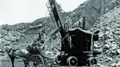The power cord for the National Construction Equipment Museum’s Marion Model 21 Electric Shovel is visible on the ground behind it, and the AC/DC motor/generator that powers the motors can be seen inside the back doors.
