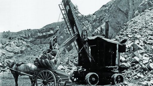 The power cord for the National Construction Equipment Museum’s Marion Model 21 Electric Shovel is visible on the ground behind it, and the AC/DC motor/generator that powers the motors can be seen inside the back doors.