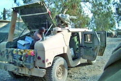 A technician servicing/installing the system, working inside the right rear quarter of the vehicle.