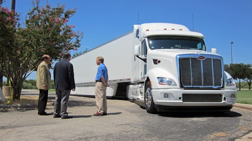 Peterbilt representatives Don Vollmar (left) and Rick Mihelic (right) present the advanced concept SuperTruck vehicle for U.S. Rep. Michael C. Burgess, M.D. (center).
