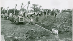 The ability of sidebooms and pipelayers to walk with a long strand of pipe makes possible a project like this. Bechtel Corporation is walking a 600-foot strand of pipe into the Niagara River for the Tennessee Gas Transmission Company on September 11, 1954. This was the first pipeline to cross the Niagara, and a fleet of Cat MD7s, equipped with extra counterweights, is doing the honors. The MD7 was a very popular sideboom; fleets of them still turned up in pipeline auctions into the early 2000s.