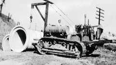 The problems involved in placing pipe with an end boom are illustrated by this rather crude rig, designed by R. G. LeTourneau for a Cat Sixty and used by his construction company on the grading contract for Southern Pacific Railroad's Carquinez Bridge approach in Benicia, CA, in 1929. Ballasted by sandbags, it provided ample capacity for a single section of pipe, but was unable to carry long strands along the trench.
