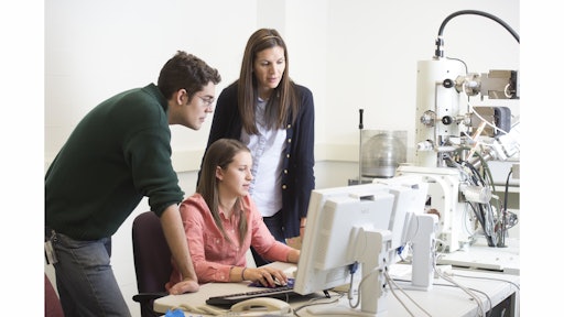 From left, WPI materials science PhD candidates Shaymus Hudson and Baillie McNally and postdoctoral student Danielle Belsito examine metal samples with a scanning electron microscope in WPI’s Materials Characterization Laboratory.