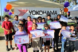 Local children show off their designs for the new playground being built by Yokohama and KaBOOM!.