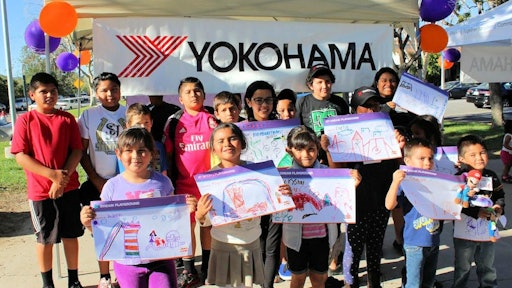 Local children show off their designs for the new playground being built by Yokohama and KaBOOM!.