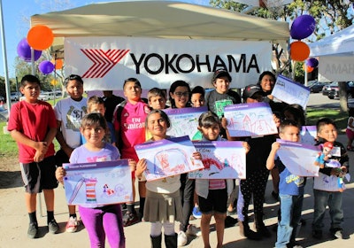 Local children show off their designs for the new playground being built by Yokohama and KaBOOM!.