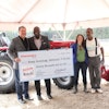 Mahindra executives Rick Haas and Cleo Franklin (left) present one of the company's five urban agriculture grants to Keep Growing Detroit's Ashley Atkinson and Willie Spivey (right).