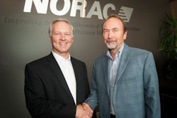 Jamie Williamson (left), Topcon Executive Vice President and General Manager of Precision Automation, shakes hands with Bill Strelioff, NORAC President and CEO, during the ceremonies at NORAC headquarters announcing its acquisition by Topcon.