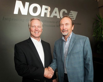 Jamie Williamson (left), Topcon Executive Vice President and General Manager of Precision Automation, shakes hands with Bill Strelioff, NORAC President and CEO, during the ceremonies at NORAC headquarters announcing its acquisition by Topcon.