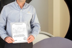 Andrea Masella standing next to the first tire produced at Trelleborg’s Spartanburg, SC plant holding the tire's “birth certificate.”