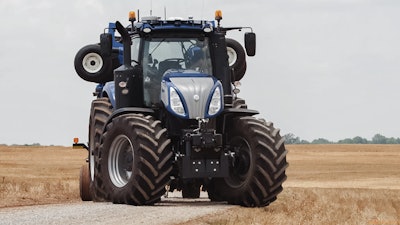 NewHolland T8 NHDrive Autonomous Concept Tractor on private farm track with the New Holland 2085 Air Disc Drill in transport position entering the field 57c6dba291640