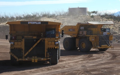 A Komatsu 930E truck (left) positioned next to a Cat 793F CMD during an autonomous mine truck demonstration at the Tinaja Hills Demonstration and Learning Center.