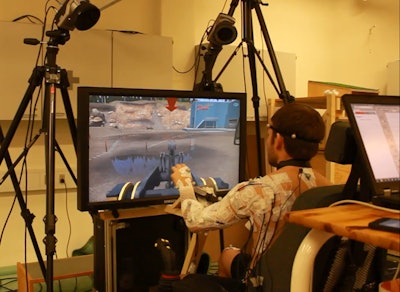 A student being monitored as he uses a simulator to operate a wheel loader with different steering input devices.
