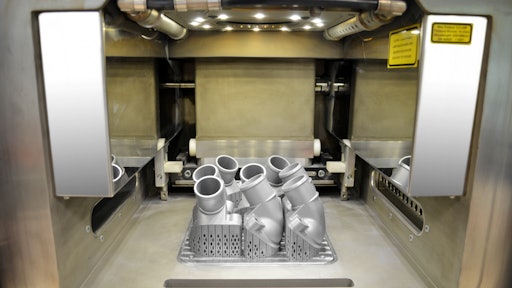 The view into the interior of a 3D printer shows the first printed thermostat covers from Mercedes-Benz (learn more, 20971198).