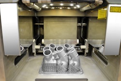 The view into the interior of a 3D printer shows the first printed thermostat covers from Mercedes-Benz (learn more, 20971198).