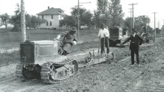 In a typical scarifier application, a Holt T-35 crawler tractor is breaking up a hard-packed roadbed prior to trimming and concrete paving.