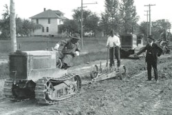 In a typical scarifier application, a Holt T-35 crawler tractor is breaking up a hard-packed roadbed prior to trimming and concrete paving.