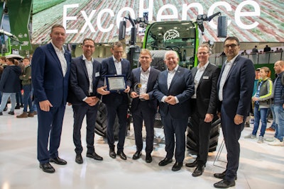 Company executives stand in front of one of its Tractor of the Year 2020 award-winning tractors.