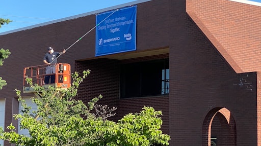 Unfurling of a banner on the Sheppard building denoting it is now part of Bendix Commercial Vehicle Systems.