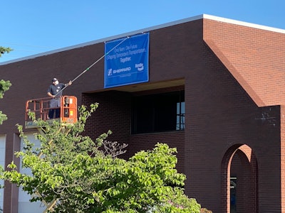 Unfurling of a banner on the Sheppard building denoting it is now part of Bendix Commercial Vehicle Systems.