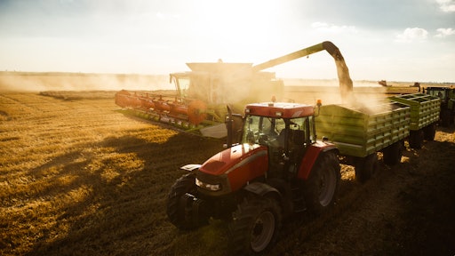Tractor And Combine Harvesting On A Sunset