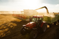 Tractor And Combine Harvesting On A Sunset