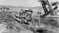 A LeTourneau Double-Drum Power Control Unit enables this Cat D7 to operate both a dozer and a pull ripper. The scene is a placer gold mine operated by Parker Brothers Corporation and Last Chance Gulch, near Helena, MT.