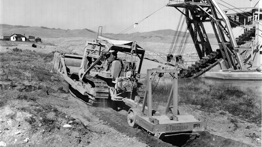 A LeTourneau Double-Drum Power Control Unit enables this Cat D7 to operate both a dozer and a pull ripper. The scene is a placer gold mine operated by Parker Brothers Corporation and Last Chance Gulch, near Helena, MT.
