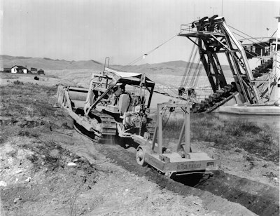 A LeTourneau Double-Drum Power Control Unit enables this Cat D7 to operate both a dozer and a pull ripper. The scene is a placer gold mine operated by Parker Brothers Corporation and Last Chance Gulch, near Helena, MT.