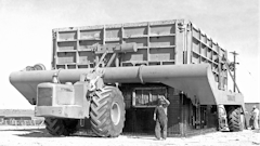 1. One of Mr. R. G.’s numerous outside-the-box, as it were, ideas was a Tournapull-powered means of pouring concrete buildings in place as a quick remedy to housing shortages. His system to achieve this revolved around the Tournalayer, a wildly overwidth trailer for A and B Tournapulls. The Tournalayer carried the complete outside forms for the structure to be poured, and after the inner forms for the outer walls had been erected the Tournalayer would be backed so as to position the outer forms above them, and then the outer forms would be lowered over the inner.