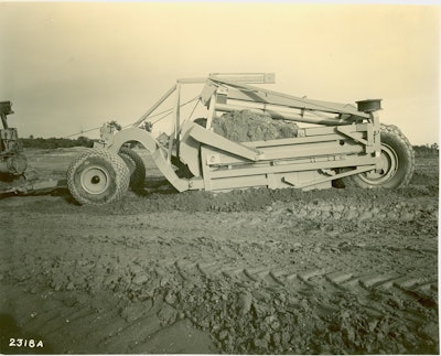 Not all of LeTourneau’s telescopic scrapers were unusually large. This Model LU Carryall has only an 11-yard heaped capacity, but this image shows the significant effect of the loading of the first of two buckets. It will soon be moved back, and the second bucket will load in its place.