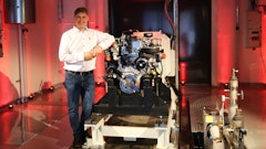 AGCO Power's Director of Engineering Kari Aaltonen in front of a hydrogen combustion engine in the new Clean Energy Laboratory.
