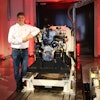 AGCO Power's Director of Engineering Kari Aaltonen in front of a hydrogen combustion engine in the new Clean Energy Laboratory.