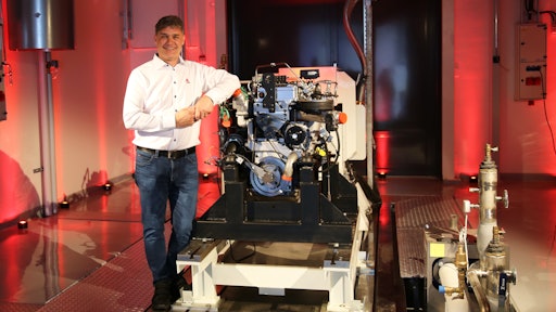 AGCO Power's Director of Engineering Kari Aaltonen in front of a hydrogen combustion engine in the new Clean Energy Laboratory.