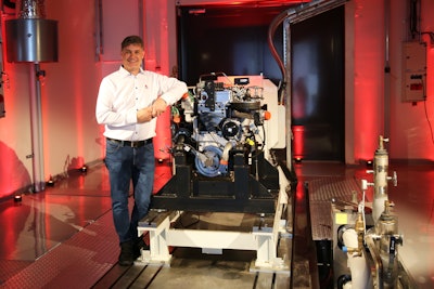 AGCO Power's Director of Engineering Kari Aaltonen in front of a hydrogen combustion engine in the new Clean Energy Laboratory.