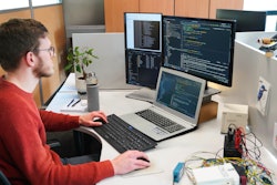 Figure 1: A software engineer at Dintec developing code for off-highway machinery.