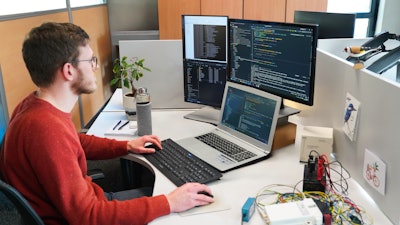 Figure 1: A software engineer at Dintec developing code for off-highway machinery.