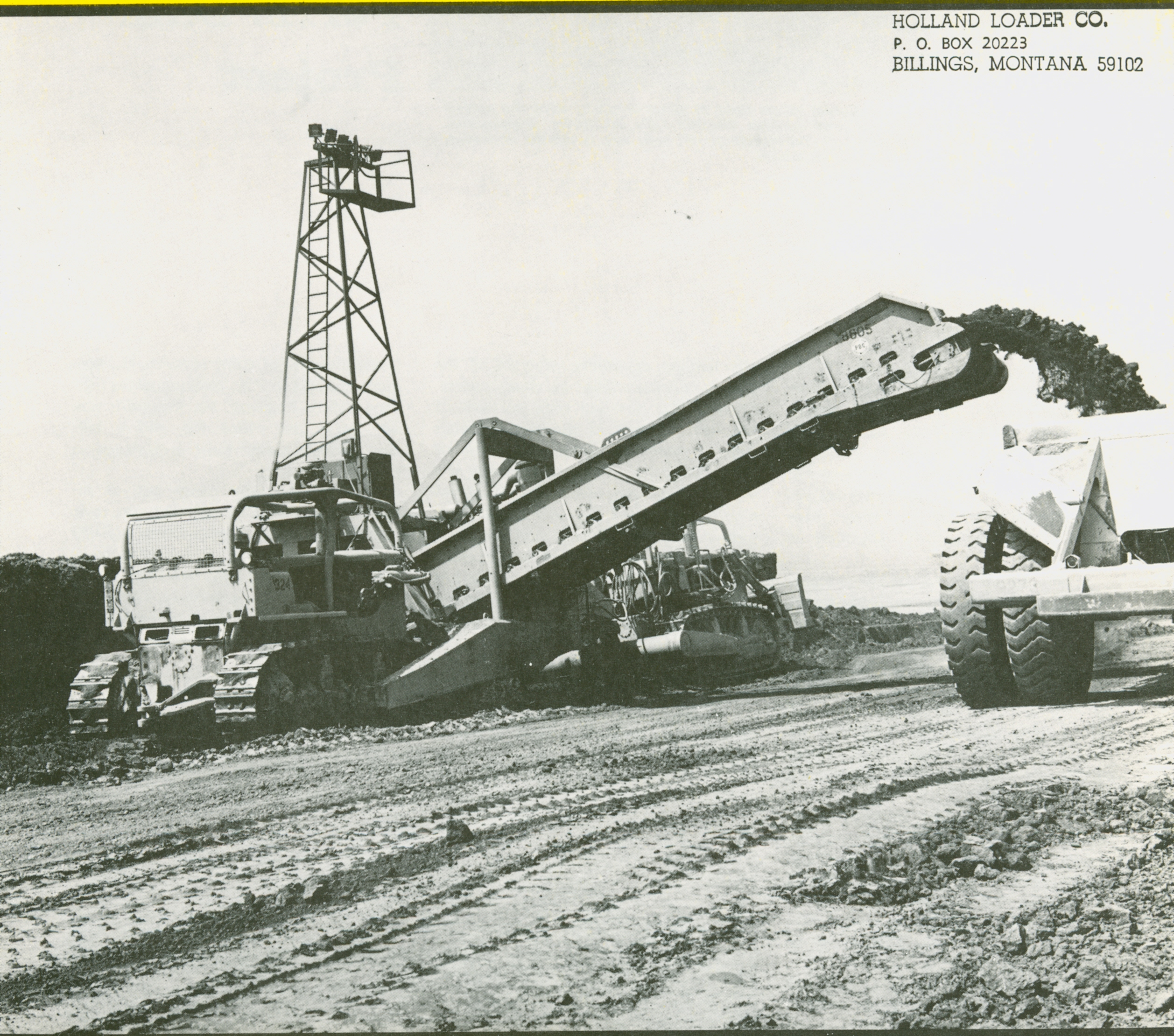 One of the four Holland loaders at Perris Dam makes quick work of loading a 110-ton capacity Euclid bottom dump. It&rsquo;s equipped with a vertical cutting edge.