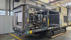 Mobile diesel generator unit with engine compartment open on industrial trailer in factory workshop