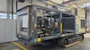Mobile diesel generator unit with engine compartment open on industrial trailer in factory workshop