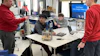 Students and instructor collaborate around a table with engineering equipment during a Field Power Team Design Challenge workshop.