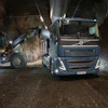 Volvo truck and wheel loader loading material in an underground mining tunnel at night