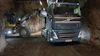 Volvo truck and wheel loader loading material in an underground mining tunnel at night